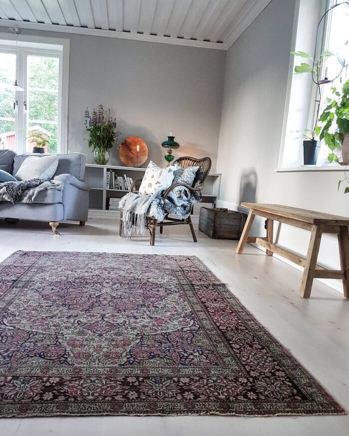 Kolorystyka szarego błękitu zapewnia spokojny, a także elegancki charakter salonu, natomiast przytulności dodają kwiaty...