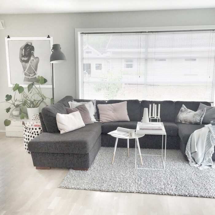 Salon prezentuje się wygodnie i stylowo. Jego główny punkt stanowi szara, sporej wielkości sofa z wieloma poduszkami w...