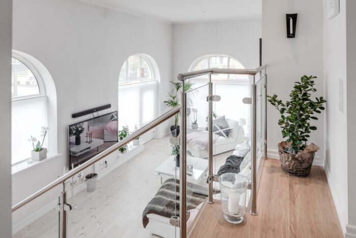 Z perspektywy schodów salon wygląda imponująco. Białą przestrzeń ozdobiono wieloma dodatkami. Szczególną rolę w...