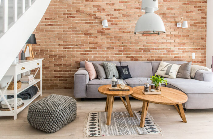 Salon jest urządzony w bardzo przytulny sposób. Czerwone cegły na ścianie dodają mu uroku, a szara sofa stanowi...