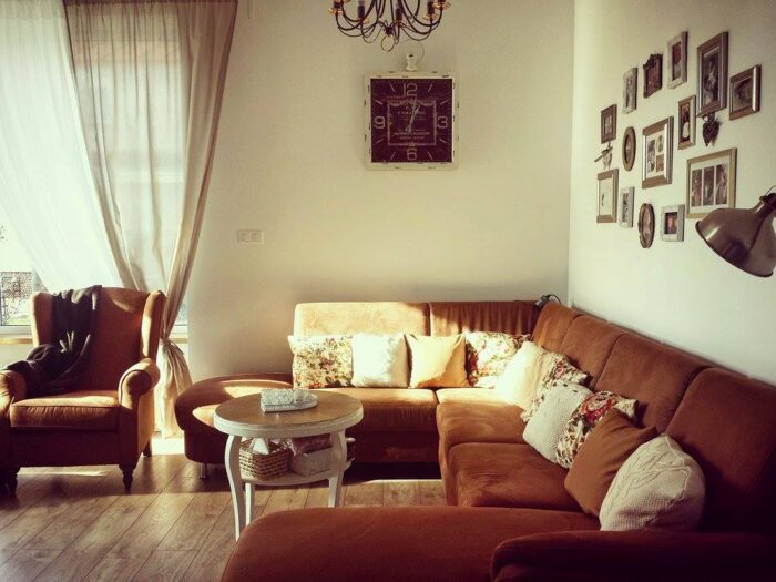 Przytulny kąt wypoczynkowy w salonie, który tworzą sporej wielkości sofa narożnikowa oraz fotel z zausznikami. Sporo...