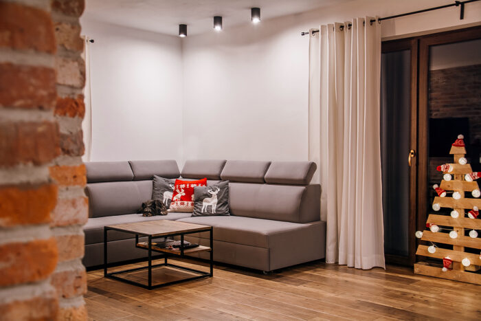Nowoczesny salon delikatnie ustrojono na Święta. W pomieszczeniu nie ma żadnych zbędnych przedmiotów czy dodatkowych...